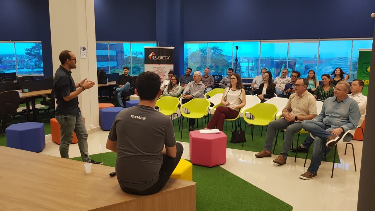 Daniel speaking to an audience in a colorful room.