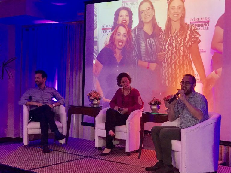 Panel on stage with purple lighting.